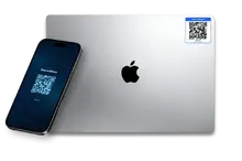 MacBook with a Return2Owner QR sticker and iPhone showing the Scan to Return lock screen